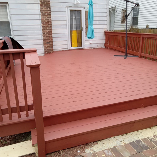 A red deck with a blue umbrella on it, perfect for relaxing outdoors on a sunny day.