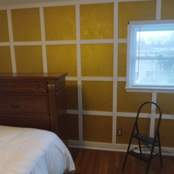 A cozy bedroom with sunny yellow walls and a comfortable bed.